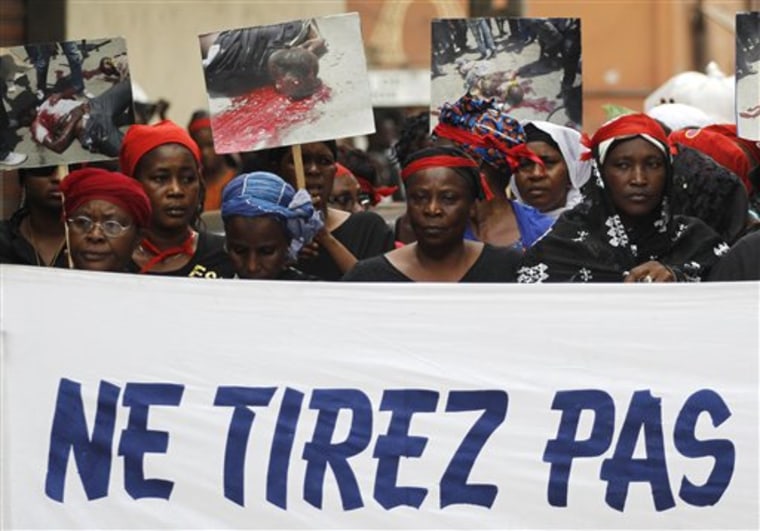 Women carry a banner reading 'Don't shoot' as they participate in a march 'of mourning' for all the victims of post-election violence, in the Treichville neighborhood of Abidjan, Ivory Coast on Tuesday.  